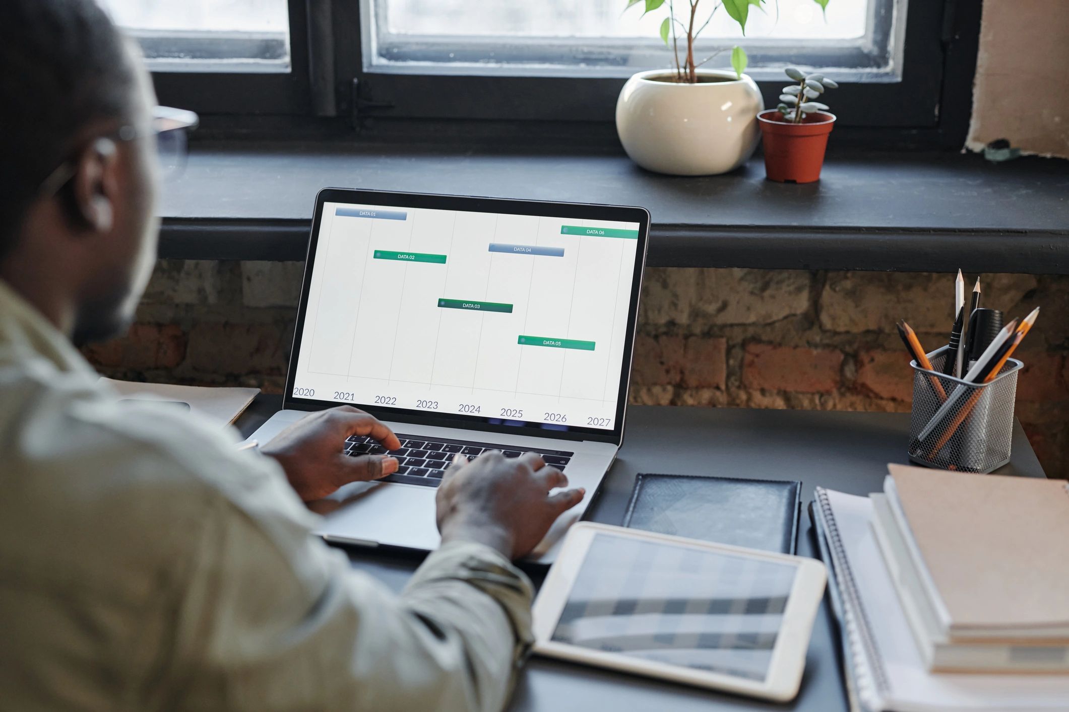Bookkeeper working at a desk with a laptop and financial data on screen